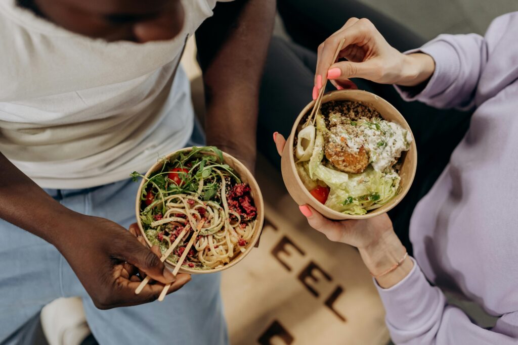 a couple of people holding bowls of food