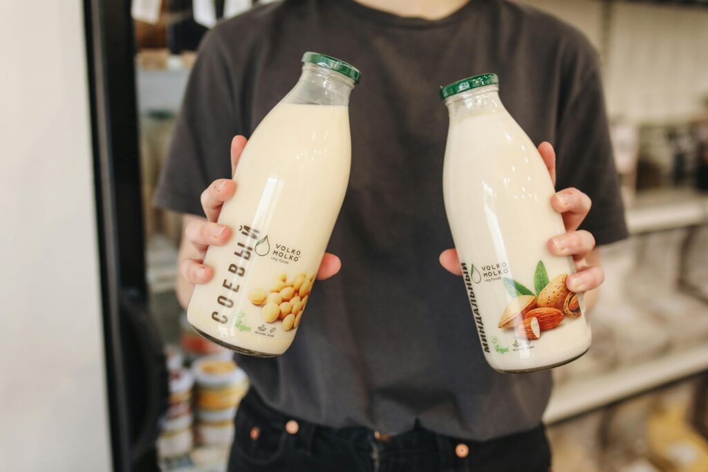 a person holding two bottles of milk